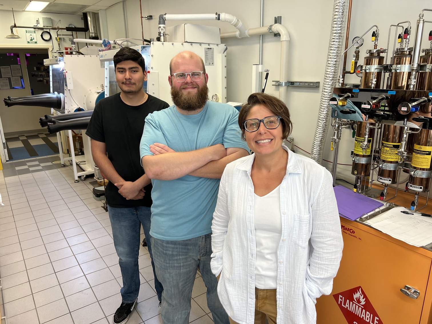 Lisa Olshansky, Peter Thompson, and Carlos Nava stand side by side in a lab where they did research. 