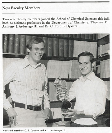 Image of a photo in a 1970s edition of the School of Chemical Sciences newsletter showing two new chemistry faculty members standing in front of a bookshelf.