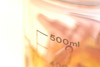 Peach colored objects in a clear beaker