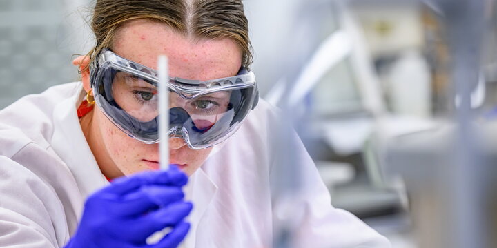 Student in lab looking at a thin tube
