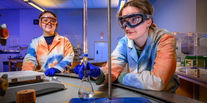 Chemists looking at a thin tube