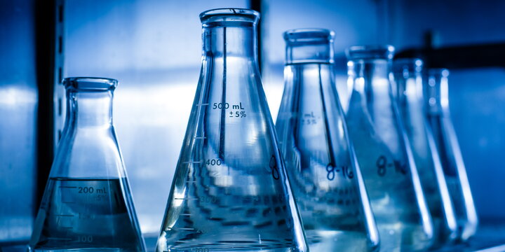 Several chemistry flasks sitting side by side in a row  