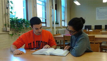 two students looking at a textbook together