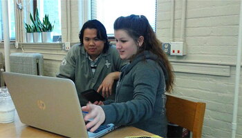 two students working together on a laptop