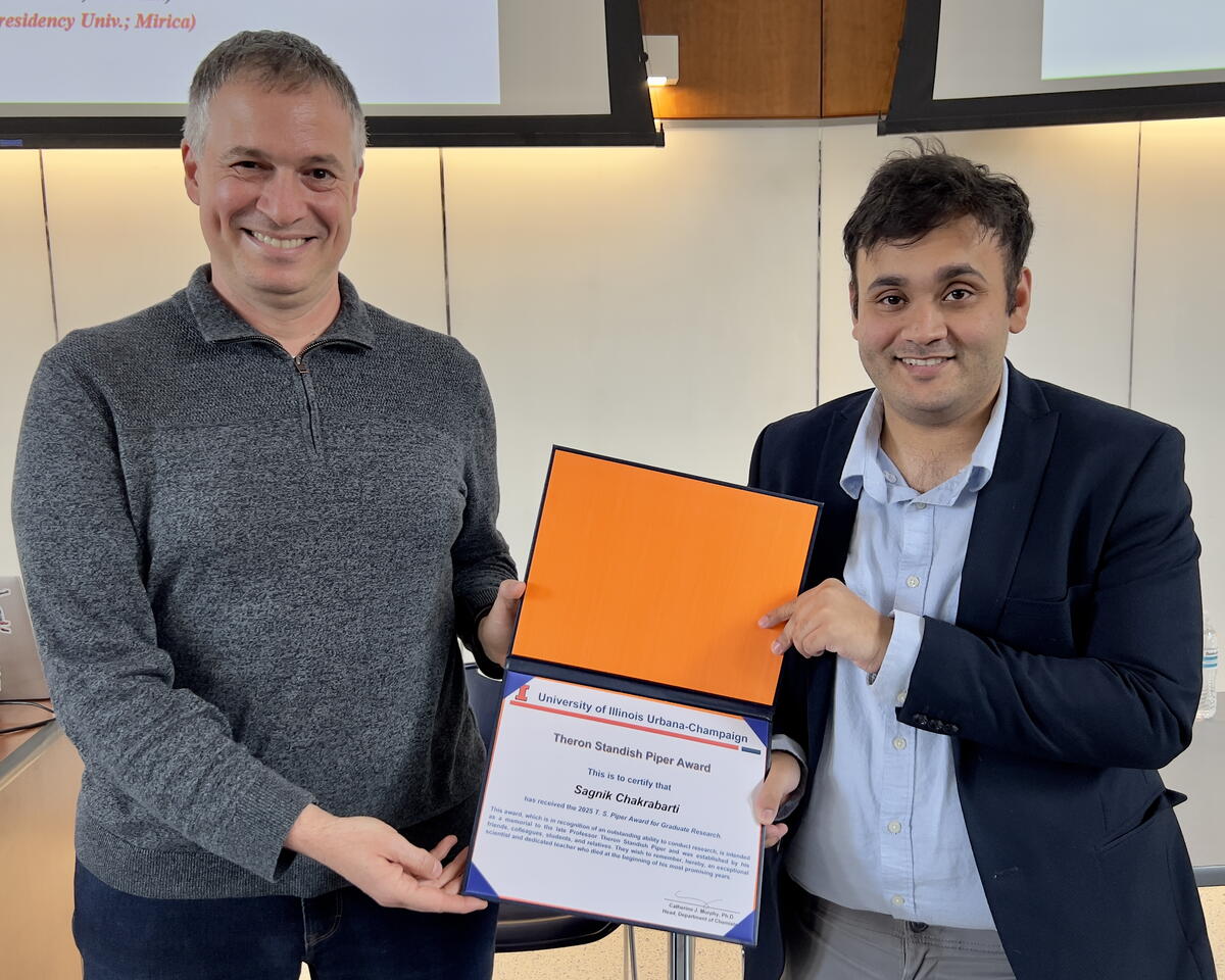 Two people standing and holding a certificate