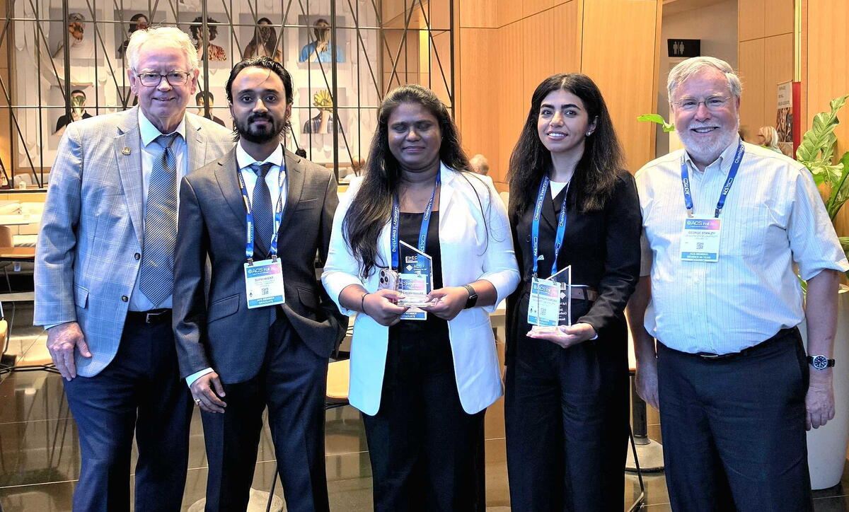 A group of people standing together holding awards