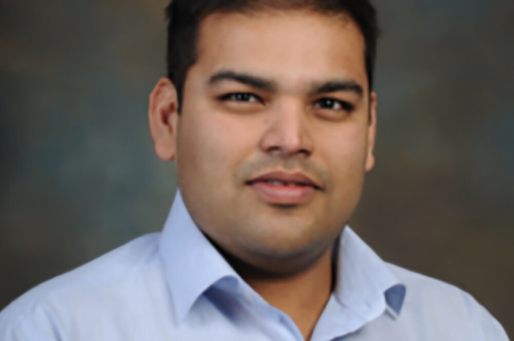 Head shot of Angad Mehta on a dark background