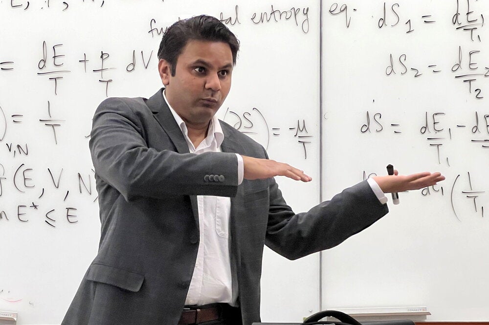 Prashant Jain teaches class standing in front of a wipe off board.