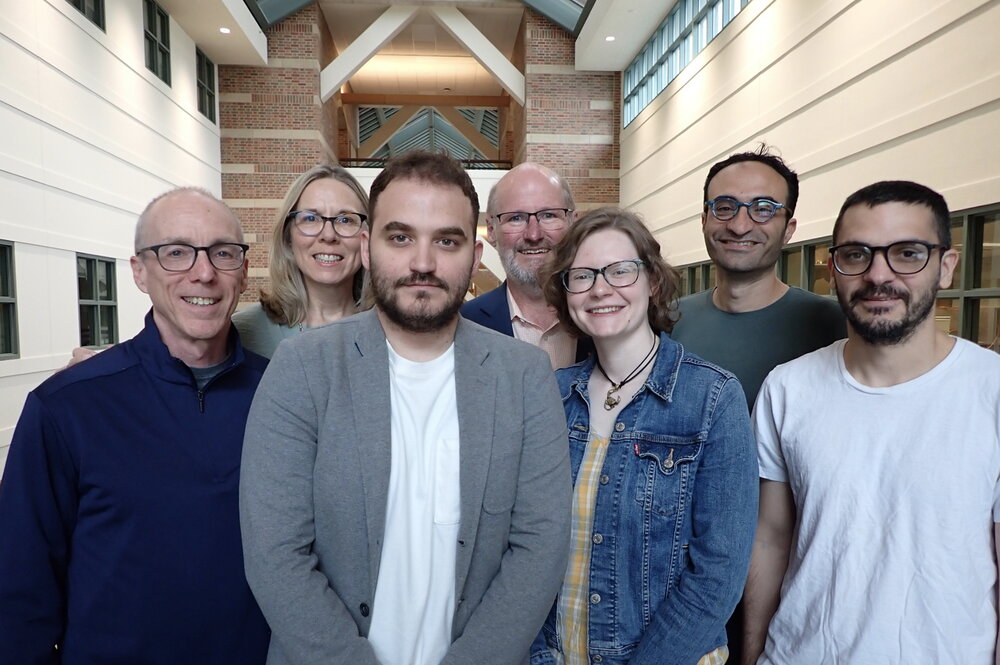 Group of researchers stand side by side in atrium of Beckman Institute.