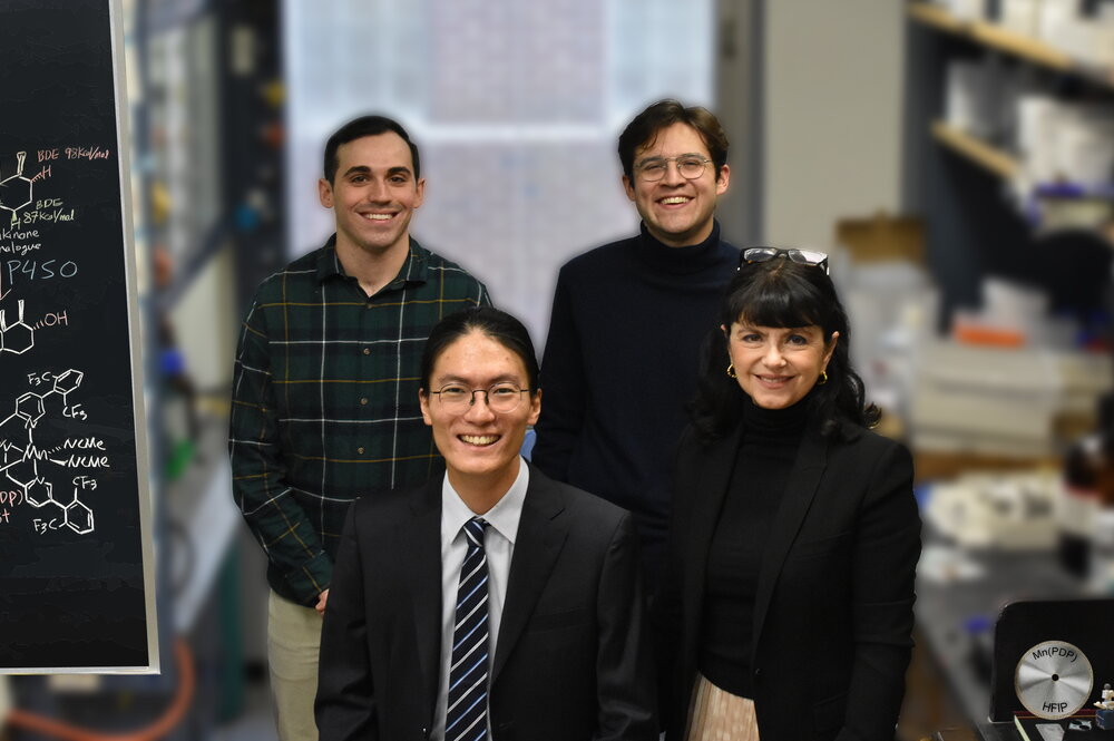 Four people standing together in a research lab