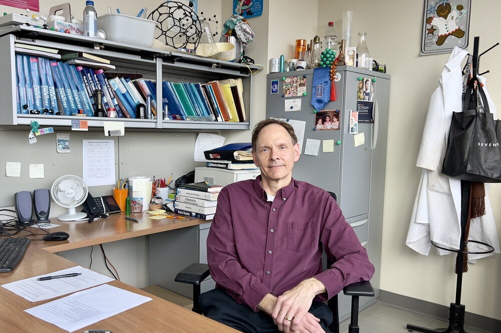 Don DeCoste sitting at a desk in his office