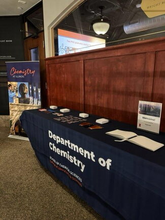 A long table at the reception with swag and a tablecloth that says Department of Chemistry