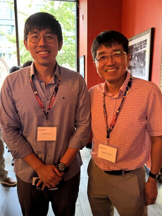 Two people standing side by side at a table