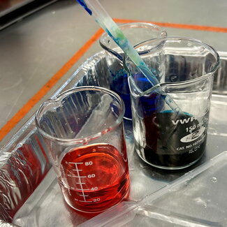 Three glass containers with colored liquids