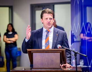 Paul Kenis speaking at a podium