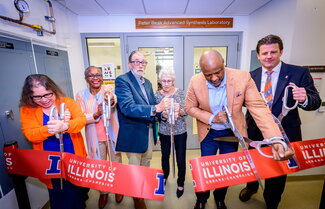 Six people cutting a ribbon with giant scissors.