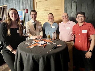Reception guests standing around a high-top table visiting