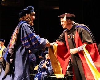 Graduate and professor shaking hands