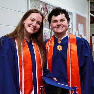 Two graduates standing side by side