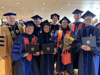 Group of graduates and faculty standing together