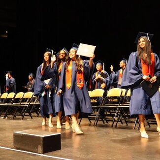 Graduate holding up diploma