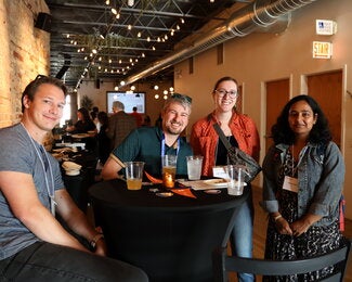 Four people at a table talking