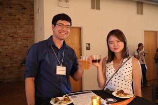 Two people standing together holding drinks