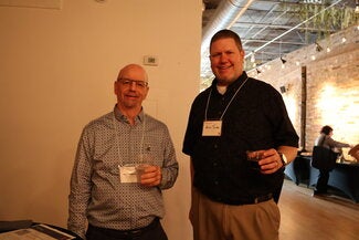 Two people standing together holding drinks