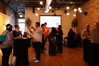 People standing and sitting at tables at a reception