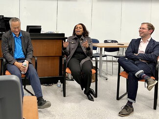 LaShaunda (seated) answers a panel question while Alan and Brett (both seated) listen.