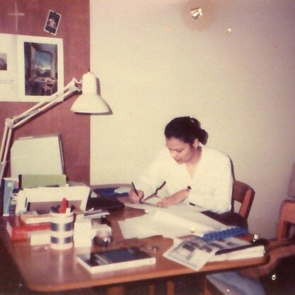 Photo from 1989 of Anna Bertelloni sitting at a desk in her Greet Street apartment working on a patent