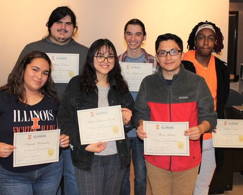 Six students who received fellowships stand side by side in two rows holding their certificates.
