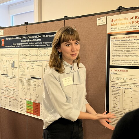 Illinois chemistry undergraduate Megan Murphy presents her research standing in front of research poster