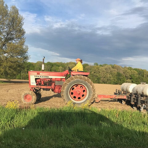 Katie Greskovich drives a tractor pulling a planter in a field in northwestern ohio.