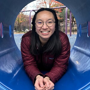 Joanna Vo laying in a plastic tube on a playground