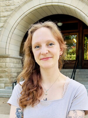 Head shot of Laura Bickart in front of an arched entrance on campus