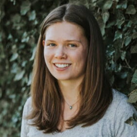 Head shot of Ellie Vandel in front of ivy