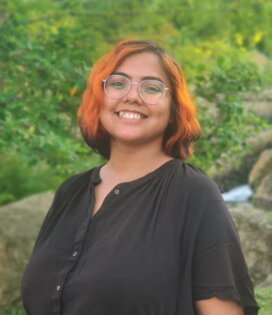 Portrait of Sukanya Dutta Standing in front of a rock waterfall