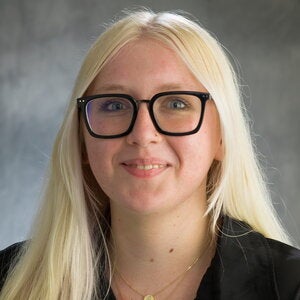 Head shot of Ella Pickell on a gray background