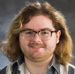 Head shot Andrew Crow on a gray background