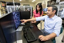 Rohit Bhargava in the lab with graduate student Yamuna Phal as they sit at computer terminals analyzing a microscopic image of solid tissue.