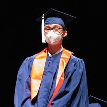 Portrait of Ryan Eleveld in graduation regalia on a black background