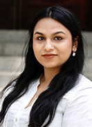 Head shot of Prakriti Das with steps in the background