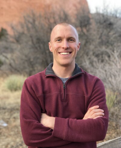 Portrait of David Friday with arms crossed standing in an outdoor setting