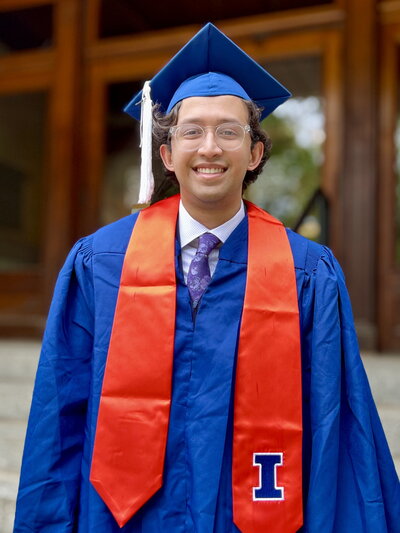 Person in cap and gown in front of Noyes entrance