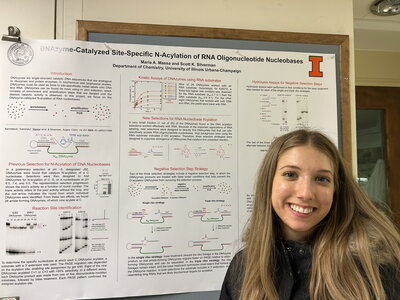 Person standing in front of a chemistry research poster
