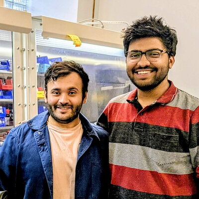 Two graduate students standing side by side in the lab