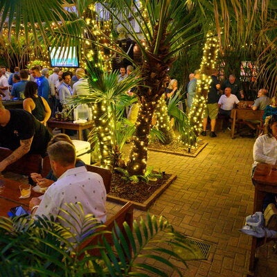 A crowd of people at a social event on a restaurant patio
