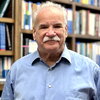 Head shot of Scott Denmark in front of a wall of books on a bookshelf