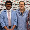 Four people in lab coats and holiday accessories stand side by side